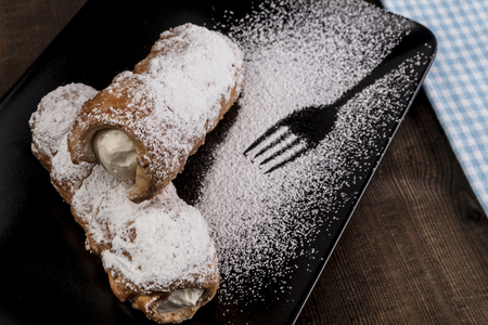 Sugar Sweets on black plate on wood tableの写真素材