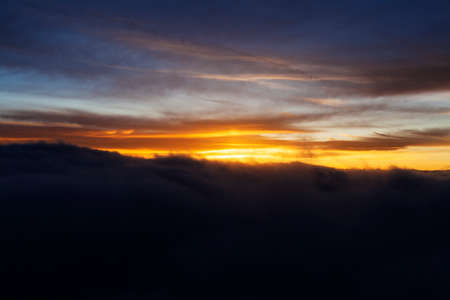 Dramatic Sunrise over fluffy clouds with bright rays of lightの写真素材