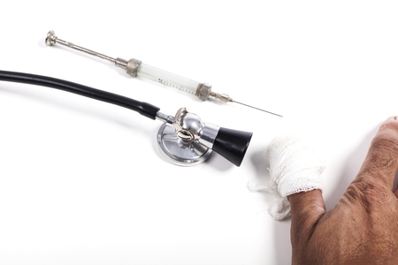 Black Stehoscope With old Glass Syringe and Bandage on Handの写真素材