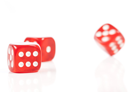 Red Casino Dice in Movement on White Backgroundの写真素材