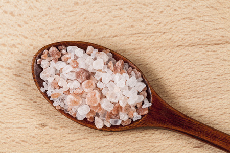Himalayan pink salt cristals on brown wood spoonの写真素材