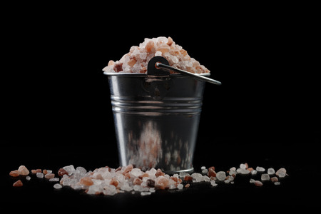 Silver Metal Bucket With Himalayan Salt on Black Backgroundの写真素材