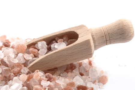 Himalayan Salt Raw Crystals Pile with Brown Wood Spice Scoop Isolated on White Backgroundの写真素材