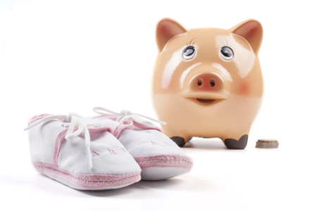 Piggy Bank With Newborn Baby Girl Shoes and Coin Isolated on White Backgroundの写真素材