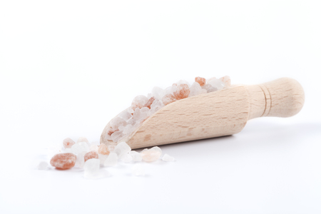 Himalayan Salt Raw Crystals Pile with Brown Wood Spice Scoop Isolated on White Backgroundの写真素材