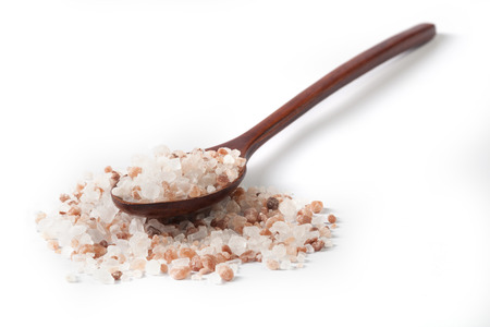 Himalayan Salt Raw Crystals Pile with Brown Wood Spoon Isolated on White Backgroundの写真素材