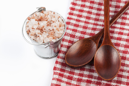 Himalayan Salt Raw Crystals Pile in Silver Metal Bucket and Two Wood Spons Isolated on White Backgroundの写真素材