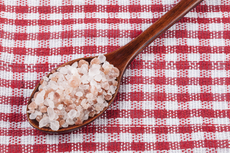 Himalayan Salt Raw Crystals in a Wood Spons on Red  Backgroundの写真素材