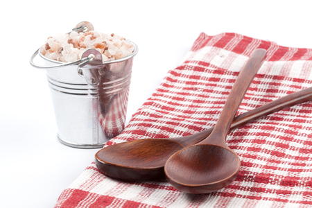Himalayan Salt Raw Crystals Pile in Silver Metal Bucket and Two Wood Spons Isolated on White Backgroundの写真素材