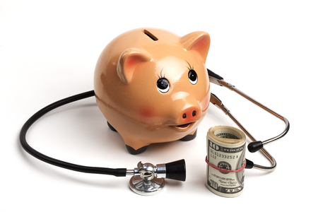 Cute Piggy Bank With Black Stethoscope and Dollars Roll Banknotes Isolated on White Backgroundの写真素材