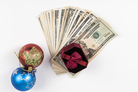 Dollar pile and gift box with Christmas decorations isolated on white backgroundの写真素材