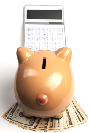 Piggy Bank On Dollars and Calculator Isolated on White Backgroundの写真素材