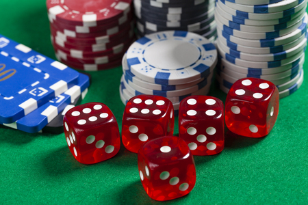 Red Dice and Casino Chips on Green Poker Tableの写真素材