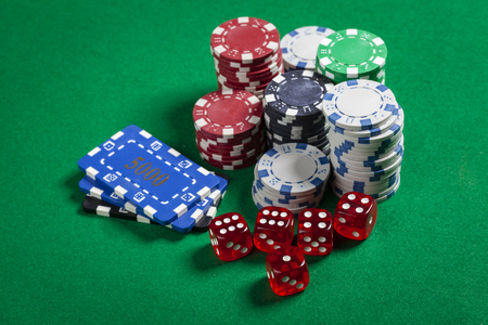 Square and Round Casino Chips With Red Dice on Green Tableの写真素材