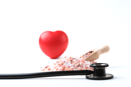 Black Stethoscope with Salt and Red Heart Isolated On White Backgroundの写真素材