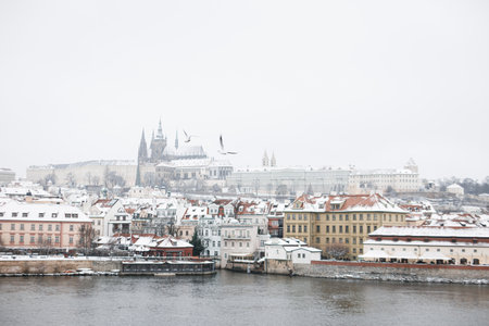 Snow in Prague, rare cold winter conditions. Prague castle in Czech Republic, snowy weather with buildings.のeditorial素材