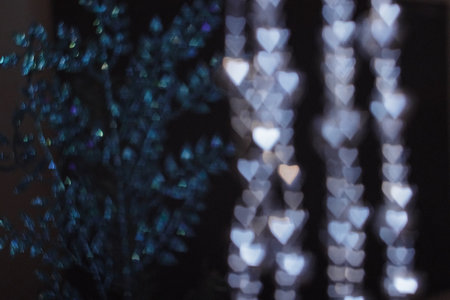 Violet christmas hearts bokeh glittering on dark background. New Year 2025. High quality photo