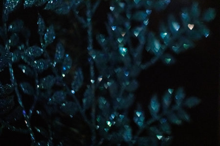 Blue christmas ornament glittering on dark background with bokeh effect