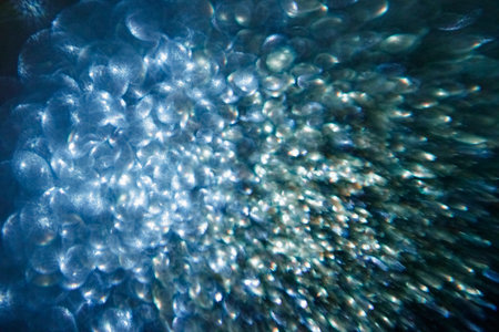 Abstract blue festive background with sparkling glitter creating bokeh effect
