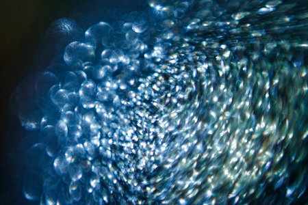 Abstract blue festive background with sparkling glitter creating bokeh effect