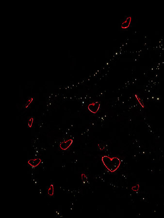 Red heart shaped lights create a romantic atmosphere in the night sky above Prague, Czech Valentines day copy spaceの写真素材