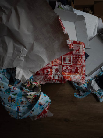 Colorful christmas wrapping paper lies crumpled on a wooden floor, suggesting a festive celebration in pragueの写真素材