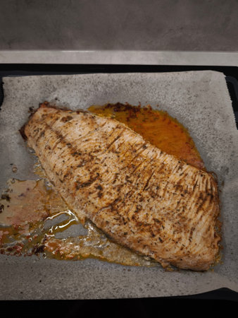 Seasoned carp fillet roasting on parchment paper, prepared for a festive Christmas dinnerの写真素材