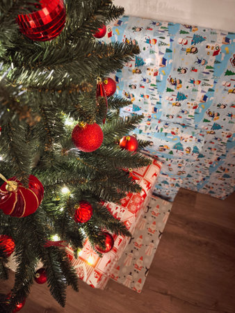 Christmas tree with red ornaments and wrapped gifts underneath, creating a festive holiday scene New Year preparation decorの写真素材