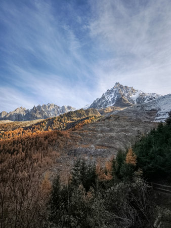 Stunning autumnal colors paint the slopes of the French alps Mont Blanc beneath the snow capped peak...