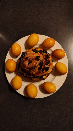 Top view of a traditional easter composition with golden colored eggs encircling a round sweet bread...