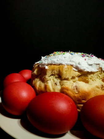 Easter cake bread Kulich featuring red eggs, white icing, colorful sprinkles, symbolizing springtime...