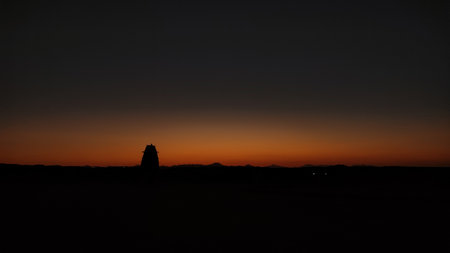 Sunset painting orange sky over egyptian desert with building silhouette in marsa alamの写真素材