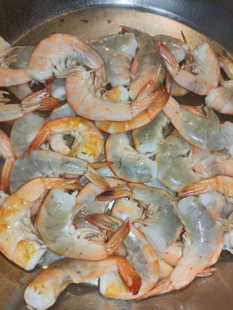 Fresh shrimps are cooking in a pan, offering a glimpse into the culinary scene of bibione, Italy, during the summer month of Julyの写真素材