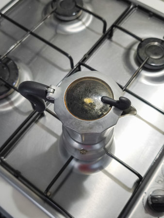 Overhead view of a moka pot brewing coffee on a stainless steel stove, capturing the essence of Italian cuisine culture in Aosta, Italyの写真素材