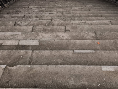 Worn stone steps showing signs of age and weathering, creating a textured urban background in...