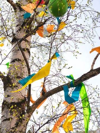 Birch tree decorated with colorful ribbons and balloons for easter celebration in Prague, Czech Republic, adding a touch of festive cheer to the cityの写真素材