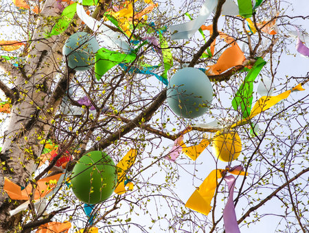 Colorful easter eggs and ribbons hanging from the branches of a tree, celebrating easter in Prague,...