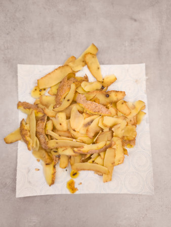 Potato peels resting on an absorbent paper towel, drying after being peeled, ready for composting or disposalの写真素材