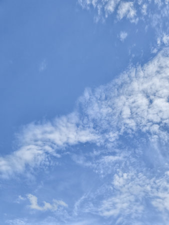 Beautiful white clouds gently float across a vibrant blue sky, creating a peaceful atmosphere