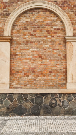 Intricate details of a building in Prague Vysehrad featuring a brick wall with an arch, stone pavement, and cobblestone walkway, highlighting the city's rich architectural heritage copy spaceの写真素材