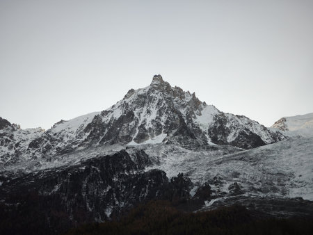 Stunning view of snow covered mountain peaks under a clear sky, showcasing the serene beauty of...