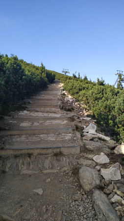 Steep hiking trail leading up to the summit of snezka mountain, with chairlift infrastructure...