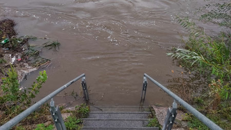 Flooded vltava river covering stairs after heavy rainfall in pragueの写真素材