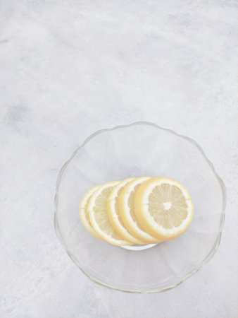 Lemon slices piled in glass bowl on marble countertop