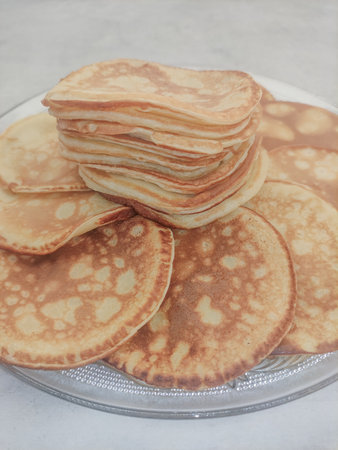 Stack of pancakes forming a delicious golden tower on a plate
