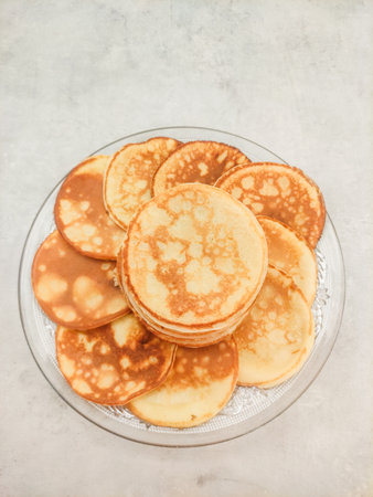 Delicious homemade pancakes stacked on a glass plate