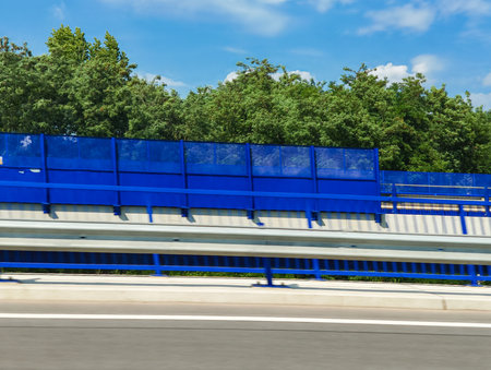 Blue soundproof wall running alongside a highway, effectively reducing noise pollution for nearby residents and preserving the tranquility of the surrounding environment in Czechiaの写真素材