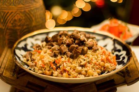 A beautifully arranged plate of Uzbek pilaf, featuring fluffy rice, succulent meat, and colorful vegetables, set against a warm, inviting background that enhances the dining experienceの写真素材