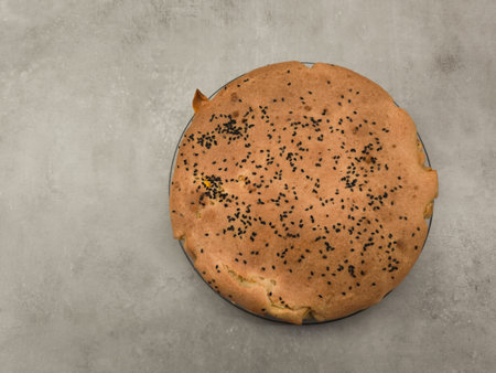 Round homemade pie decorated with black sesame seeds on a gray table copy space gray backgroundの写真素材