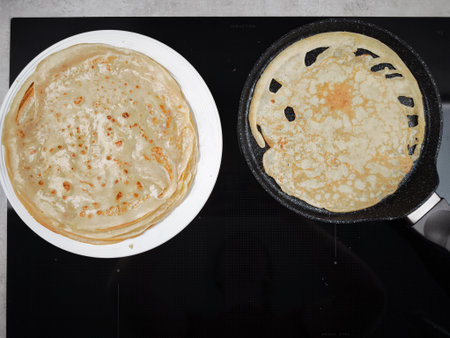 Cooking crepes for shrove tuesday or pancake day, maslenitsa or breakfast, preparing a stack of...